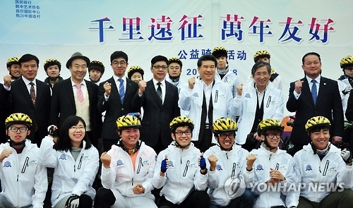 10月28日,在首爾世界盃體育場,2016“同行南韓·人文之旅”在韓中國留學生公益騎行系列活動抱川站啟幕。圖為中國留學生騎友與主要代表發車前合影留念。韓聯社