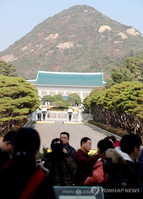 11月17日,在青瓦臺正門外,一群中國遊客遙望樸槿惠居所。