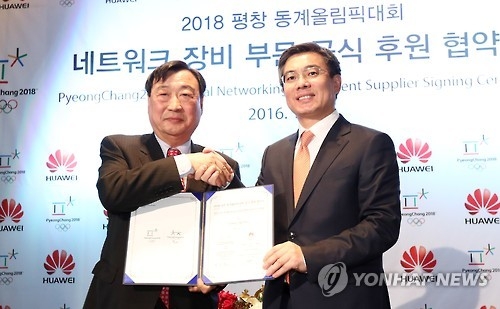 12月13日,在首爾四季酒店,華為企業BG總裁閻力大(右)和平昌冬奧組委主席李熙范代表雙方簽署贊助協議後合影。(韓聯社)