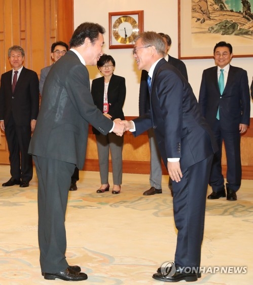 5月31日,在青瓦臺,南韓總統文在寅(右)與新總理李洛淵握手。(韓聯社)
