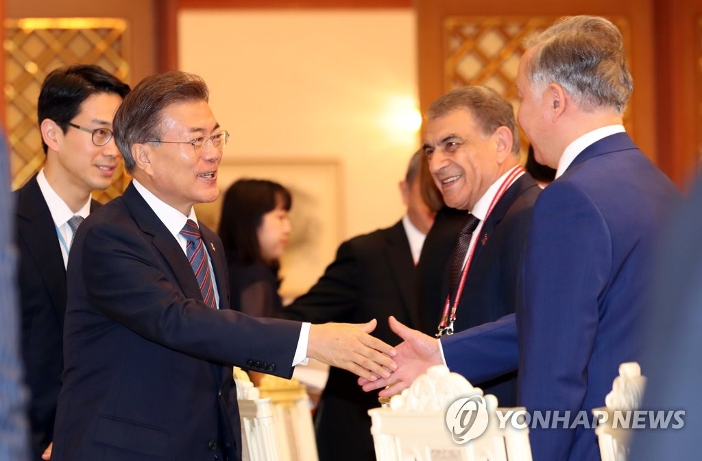 6月27日,南韓總統文在寅出席歐亞國家議長會議午宴,與各國代表親切握手。(韓聯社)