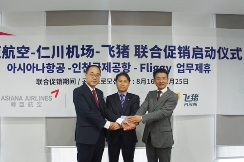 8月2日,在北京,飛豬國際機票平臺商務合作總經理湯文開(右一)與韓亞航空及仁川機場代表手牽手啟動聯合促銷活動。(韓聯社/韓亞航空提供)