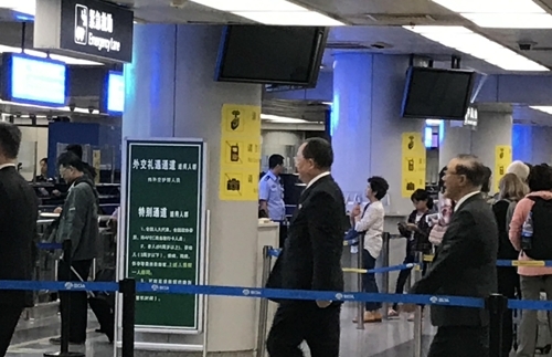 9月28日,在首都機場,李勇浩(右二)走入外交禮遇通道。(韓聯社)