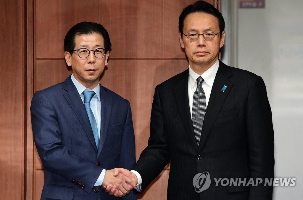 1月8日,在首爾南韓外交部大樓,南韓外交部東北亞局長金容吉(左)和日本外務省亞洲大洋洲局局長金杉憲治在會談前握手合影。(韓聯社)