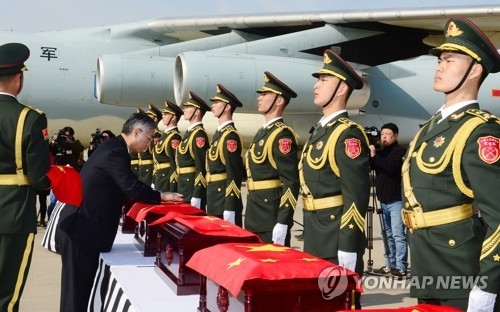 資料圖片:2017年3月,在仁川機場,中國駐韓大使邱國洪為志願軍遺骸棺槨覆蓋五星紅旗。(韓聯社)
