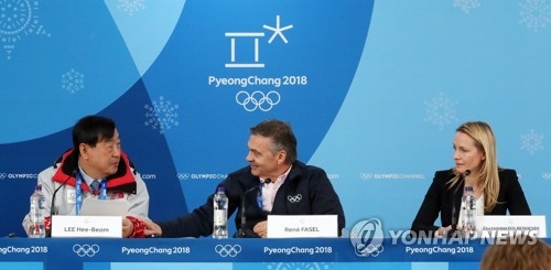 2月19日上午,在江陵冰球中心,李熙范(左)和法賽爾(居中)在國際冰聯平昌冬奧女子冰球賽中期記者會上交談。韓聯社
