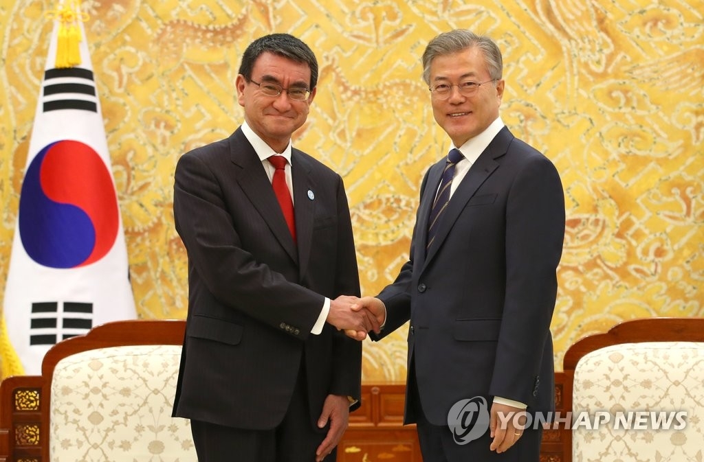 4月11日下午,在南韓青瓦臺,總統文在寅(右)接見到訪的日本外務大臣河野太郞。圖為兩人在會晤前握手合影。(韓聯社)