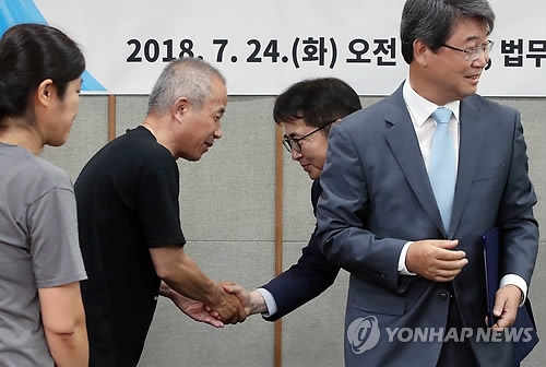 7月24日,半導體工人健康與人權守護組織代表(左二)和三星電子相關人士握手。(韓聯社)