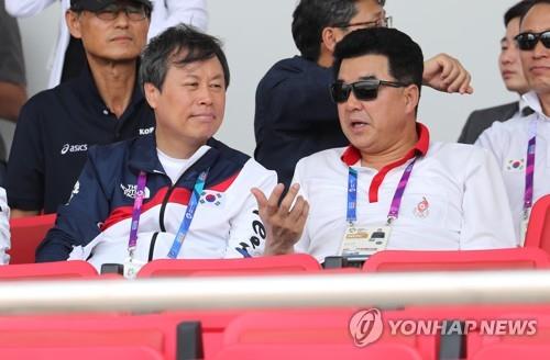資料圖片:當地時間8月22日,在印尼雅加達,南韓文化體育觀光部長官都鐘煥(左)與朝鮮體育相金一國一同觀看2018雅加達亞運會賽艇項目韓朝聯隊的比賽。(韓聯社)