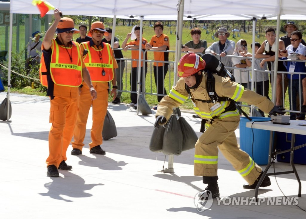 圖為最強消防員比賽現場,右為獲得該項目冠軍的南韓消防員洪范錫。(韓聯社/世界消防競技大賽促進團提供)