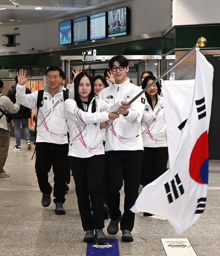 南韓時間1月31日,在義大利米蘭馬爾彭薩機場,南韓體育代表團旗手、速度滑冰選手樸智玗(左)和短道速滑運動員李俊瑞手捧南韓國旗。 韓聯社/大韓體育會供圖(圖片嚴禁轉載複製)