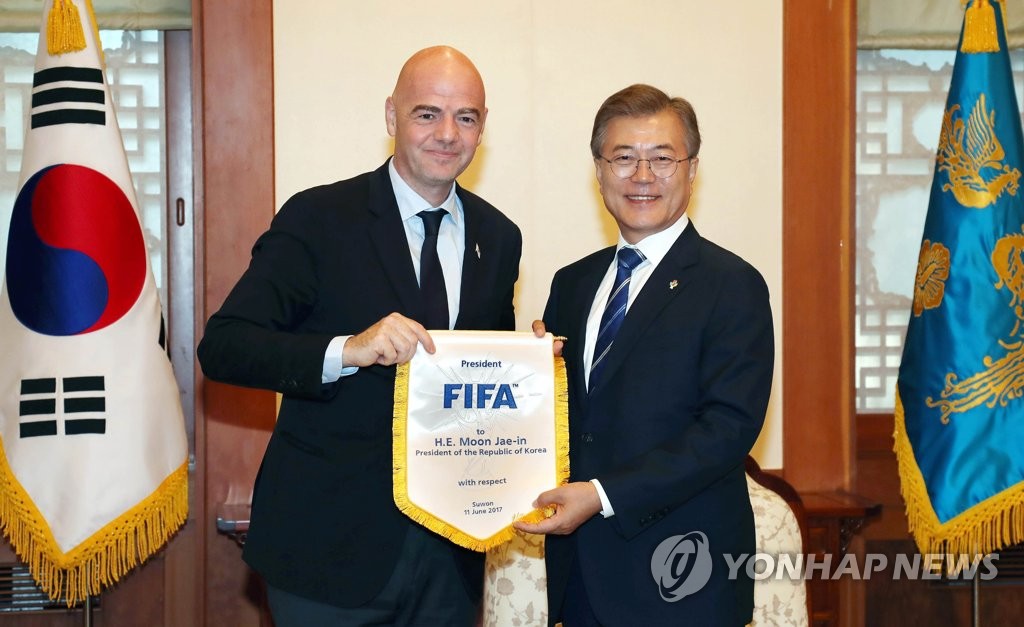 6月12日下午,在青瓦臺,南韓總統文在寅與國際足聯主席因凡蒂諾(左)合影。(韓聯社)