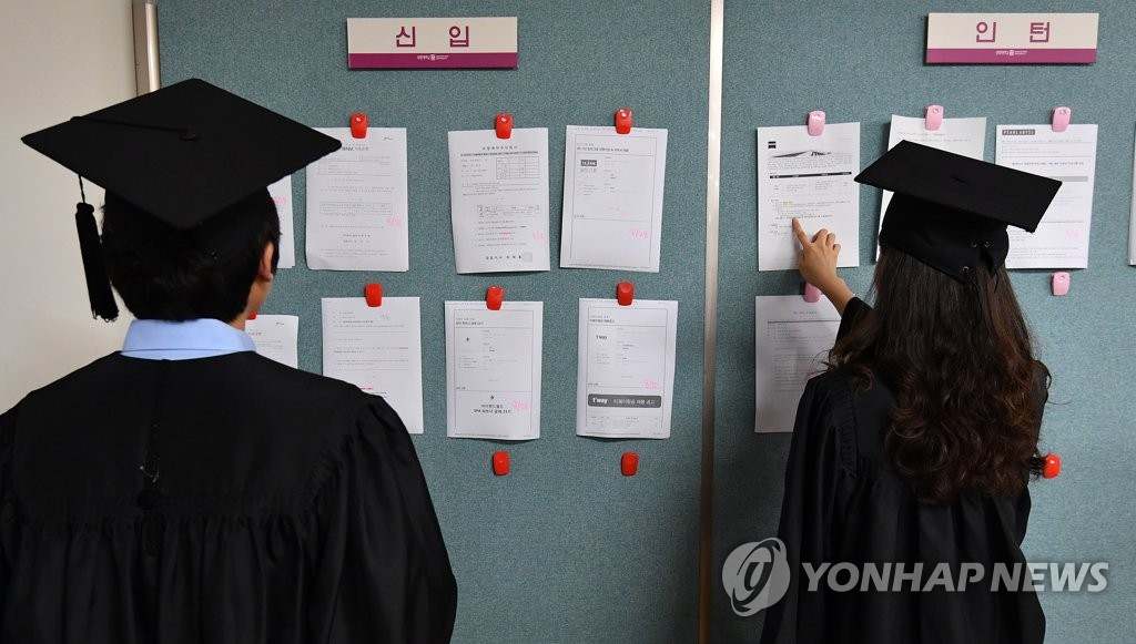 資料圖片:2017年8月23日,在位於首爾鐘路區的祥明大學,參加2017年度夏季畢業典禮的畢業生們正在瀏覽招聘資訊。(韓聯社)
