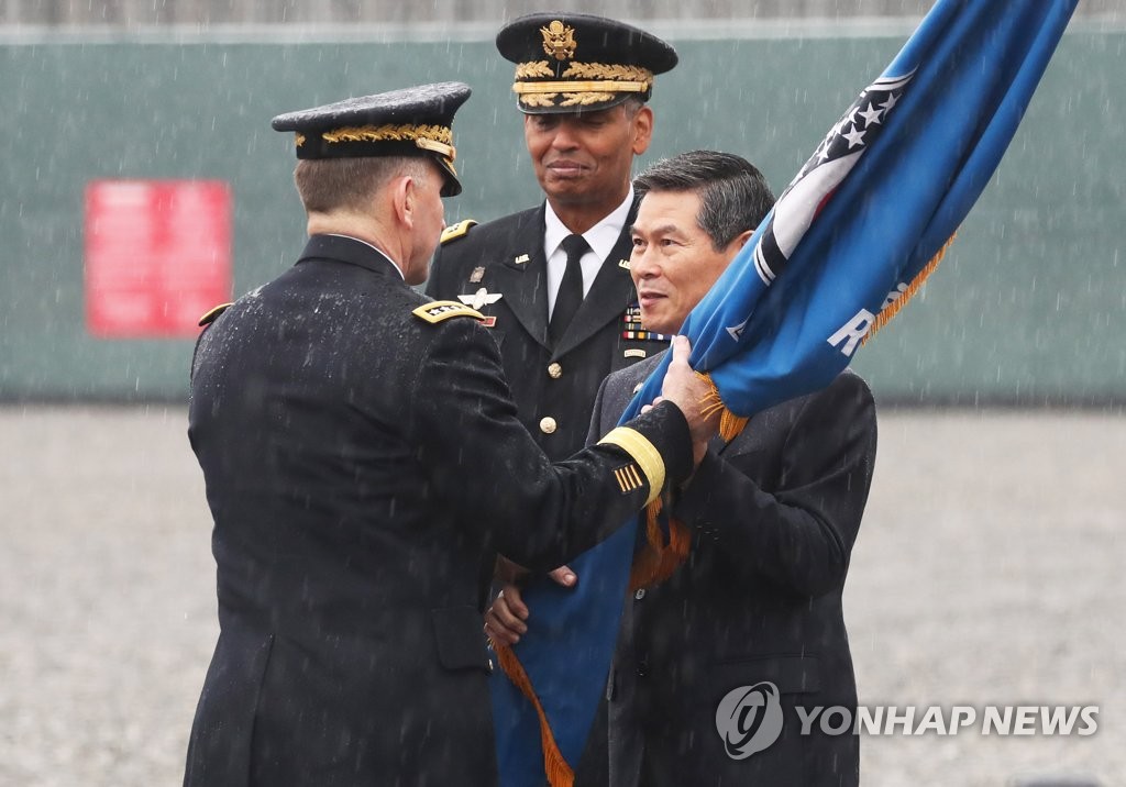 11月8日上午,在京畿道平澤基地,南韓防長鄭景鬥(右)從布魯克斯(中)手中接過軍旗,再交給艾布拉姆斯。(韓聯社)