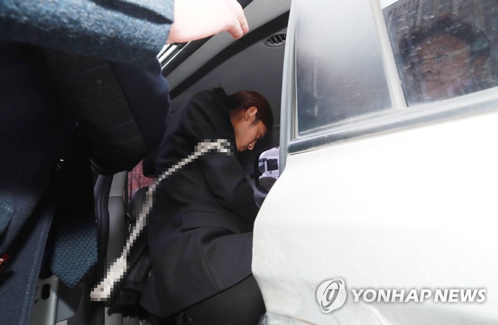 3月21日,在首爾中央地法門口,鄭俊英結束逮捕審查後上車離開法院。(韓聯社)