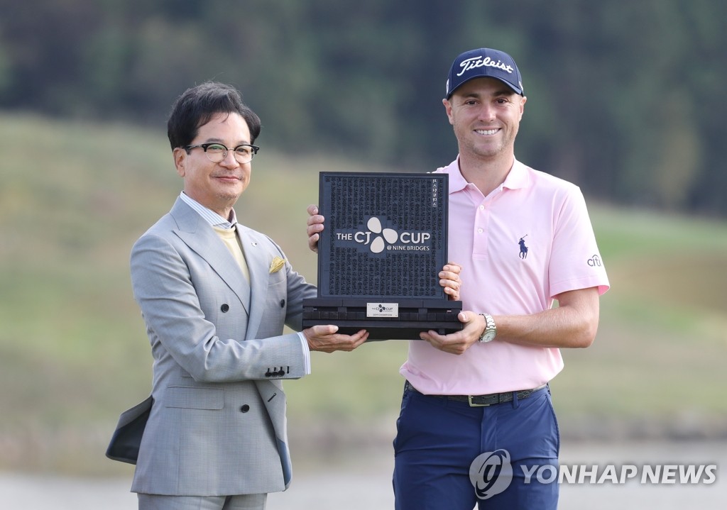 托馬斯(右)手捧美巡賽CJ杯冠軍獎盃留影。 韓聯社