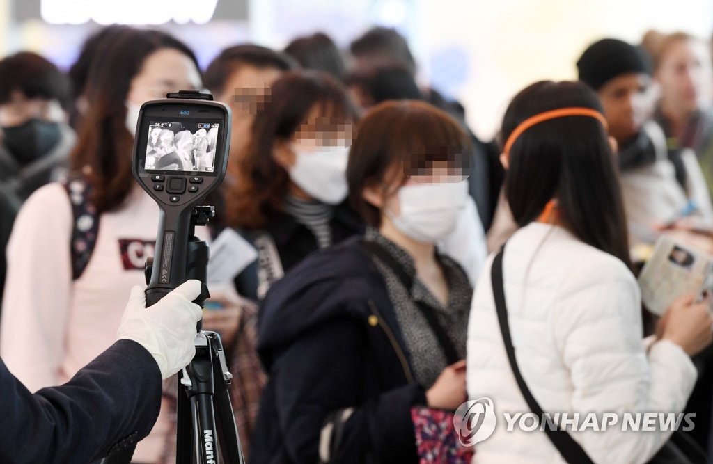 資料圖片:2月28日,在仁川國際機場洛杉磯航班登機口,大韓航空工作人員篩查發熱旅客。 韓聯社