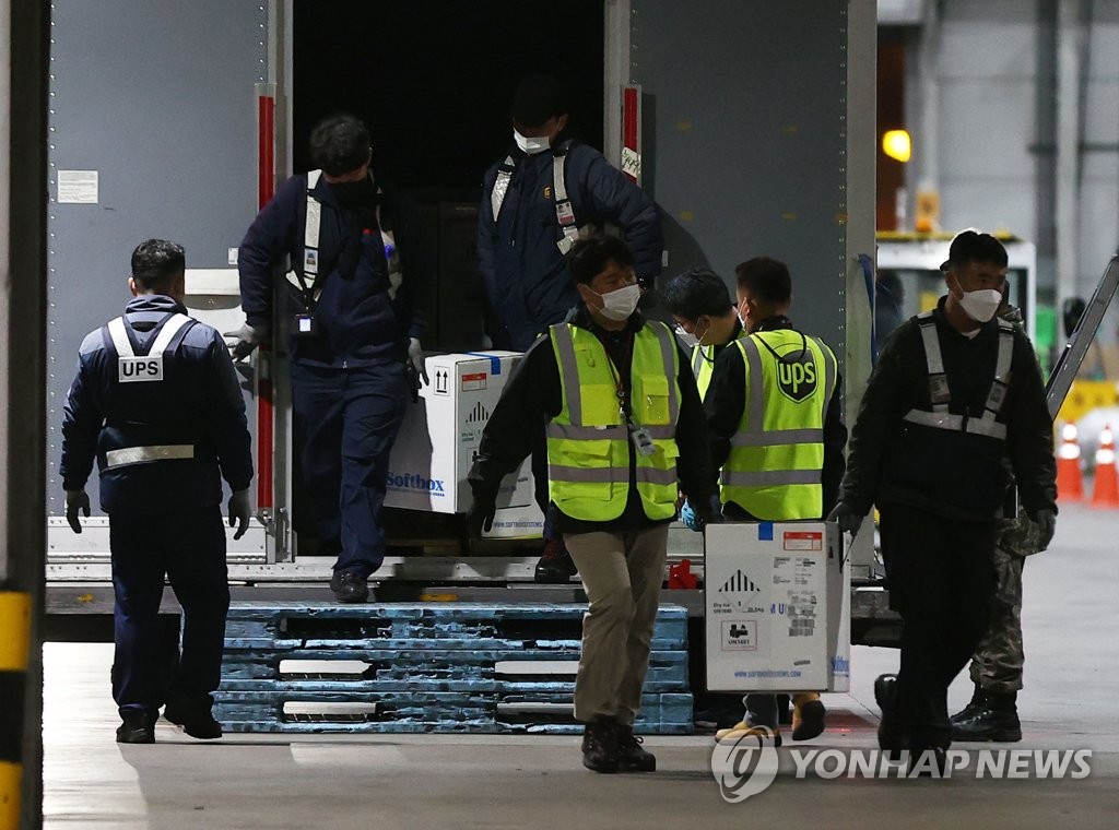 資料圖片:5月5日淩晨,新冠疫苗運抵仁川機場,工作人員從貨機卸貨。 韓聯社