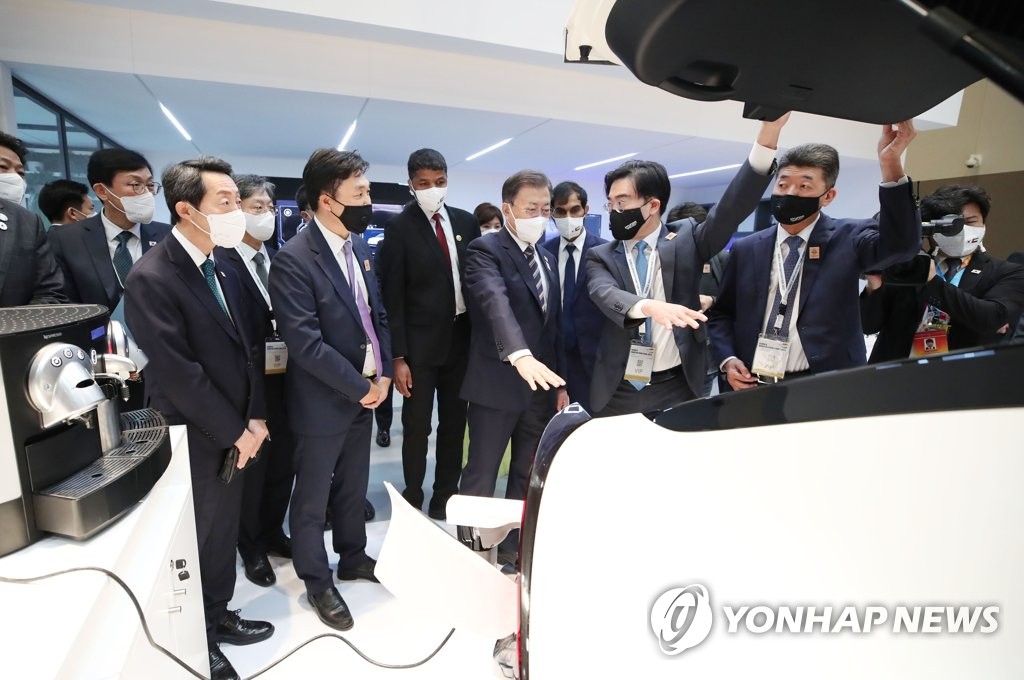 當地時間1月17日,南韓名優產品展在阿聯酋迪拜世界博覽會展館舉行。圖為南韓總統文在寅(前排右三)參觀現代汽車展區。 韓聯社