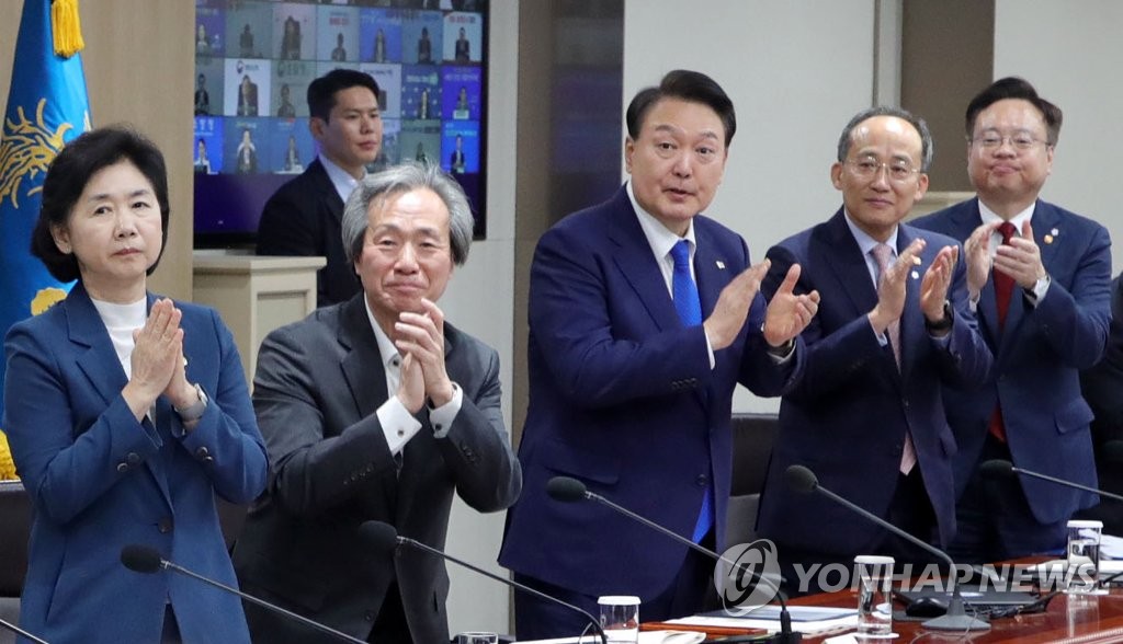 5月11日,在首爾龍山總統府,南韓總統尹錫悅(右三)主持召開防疫會議,為其間在防疫一線奮鬥的醫療人員鼓掌致意。 韓聯社/總統室通訊攝影記者團