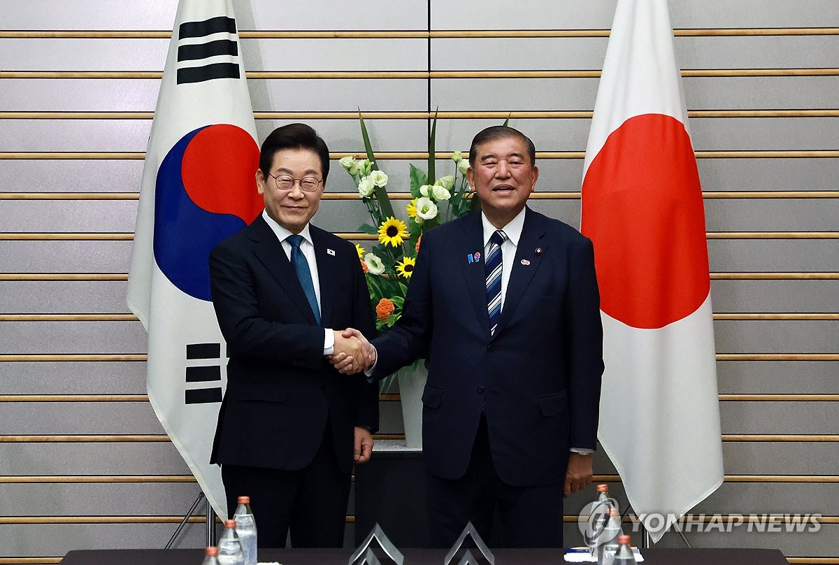 8月23日,在日本首相官邸,南韓總統李在明(左)同日本首相石破茂在大範圍會談前握手合影。 韓聯社