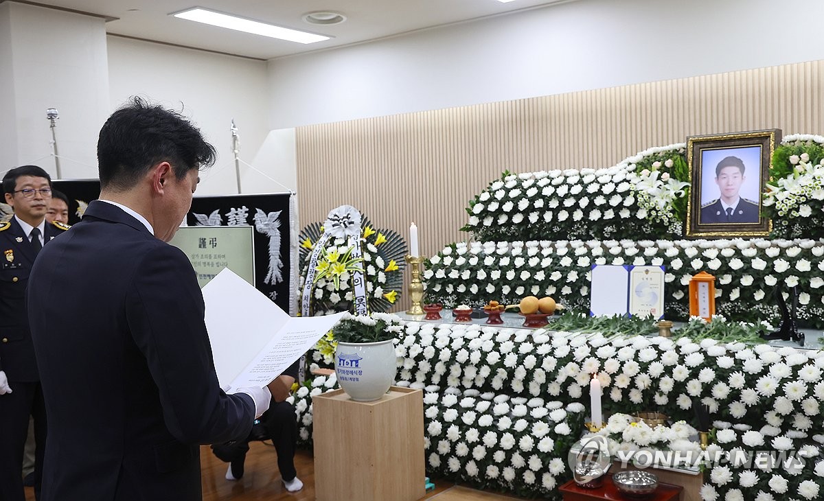 9月12日,在設在仁川市東區的一殯儀館的殉職海警李在錫靈堂,總統室秘書室長姜勳植代讀李在明發來的唁電。 韓聯社