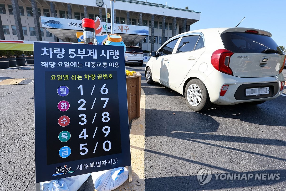 資料圖片:3月23日,濟州道政府大樓入口處擺放著汽車尾號限行告示牌。 韓聯社